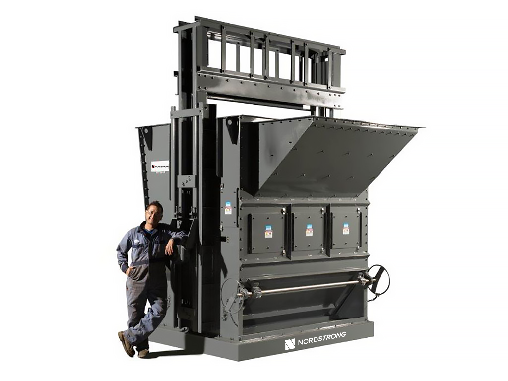 Man standing beside a large gray industrial bucket elevator boot section.